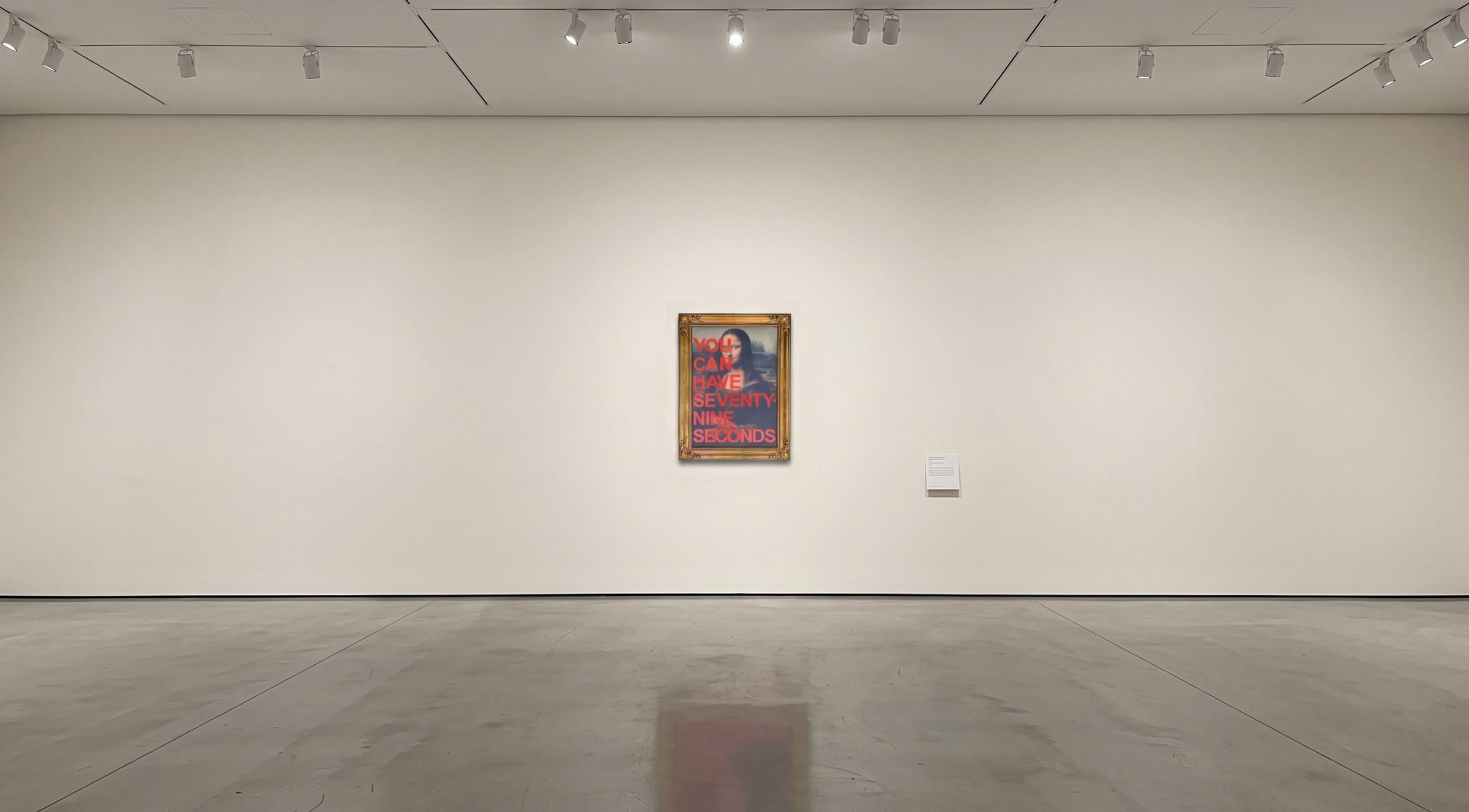 A gilt-framed Mona Lisa in a bare gallery, sprayed with the words You can have seventy-nine seconds